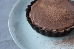 Small chocolate tart on a blue grey plate