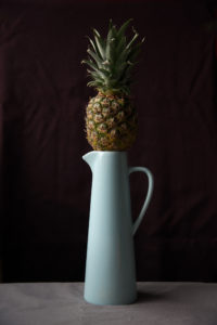 Small Pineapple on top of a blue jug