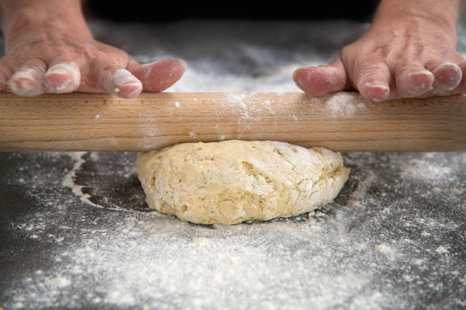 Two hands on a rolling pin - rolling pastry