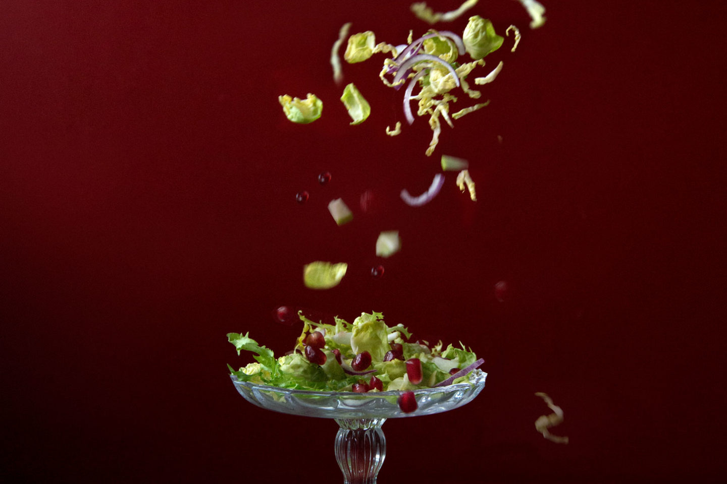 Salad leaves being dropped onto a dish