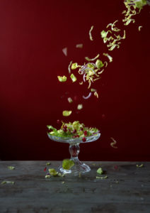 Salad leaves being dropped onto a dish